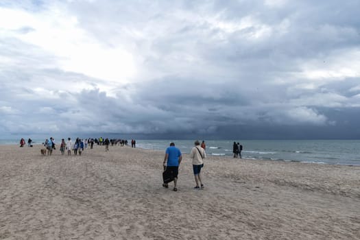 People walking along the seashore at cape Grene, Skagen Odde, Denmark - August 29, 2023.