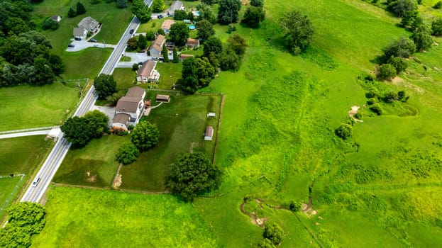 An Aerial View of Rural Homes and Green Pastureland