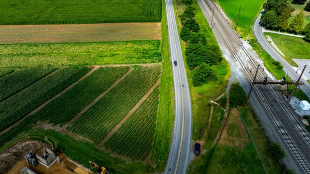 An Aerial View of Farmland with Road and Railway Tracks