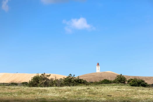 Rubjerg Knude Lighthouse on the coast of the North Sea in the Jutland in northern Denmark. Natural landscape with sand dunes. High quality photo