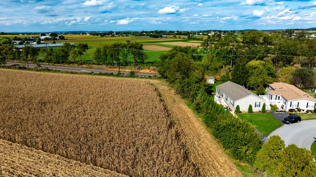 An Aerial View of Countryside Homes and Farmland with Cornfield