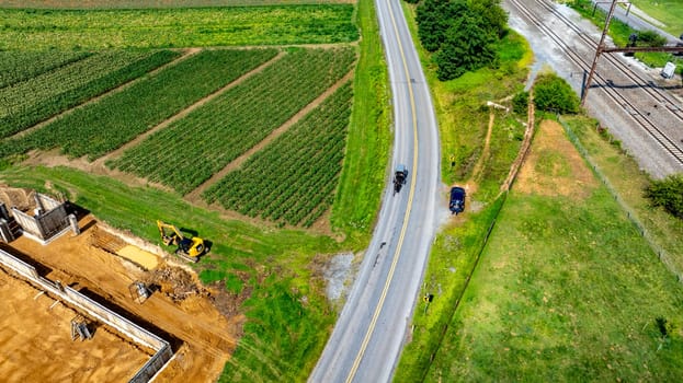 An Aerial View of Farmland with an Amish Horse and Buggy, on Road, with Railway, and Construction Site