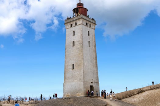 Rubjerg Knude Lighthouse on the coast of the North Sea in the Jutland in northern Denmark. Natural landscape with sand dunes. Rubjerg, Denmark - August 24, 2023.