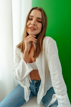 Portrait of attractive lovely girl wearing crop top and shirt posing over green studio background close up