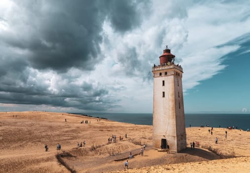 Rubjerg Knude Lighthouse on the coast of the North Sea in the Jutland in northern Denmark. Natural landscape with sand dunes. Rubjerg, Denmark - August 24, 2023.