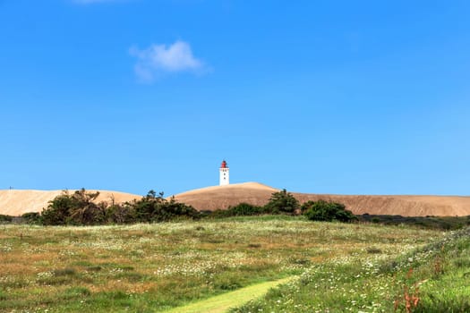 Rubjerg Knude Lighthouse on the coast of the North Sea in the Jutland in northern Denmark. Natural landscape with sand dunes. High quality photo