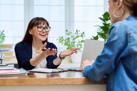 Female psychologist therapist working with young teen girl sitting in office. Teenage female student at therapy meeting with counselor. Psychology therapy psychotherapy youth mental health treatment