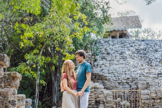 Couple, man and woman tourists at Coba, Mexico. Honeymoon Ancient mayan city in Mexico. Coba is an archaeological area and a famous landmark of Yucatan Peninsula. Cloudy sky over a pyramid in Mexico.