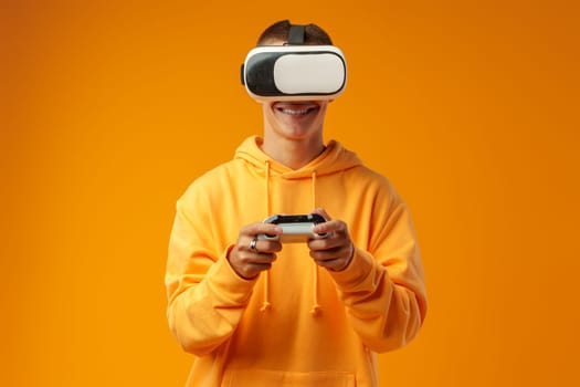 Young man using virtual reality headset against yellow background in studio