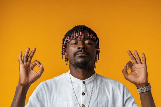 African man standing over isolated yellow background relax and doing meditation gesture with fingers, close up