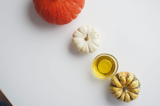 Pumpkin seed oil in glass on white background