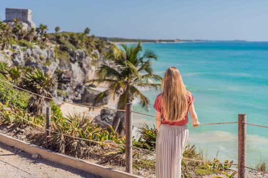 Woman tourist enjoying the view Pre-Columbian Mayan walled city of Tulum, Quintana Roo, Mexico, North America, Tulum, Mexico. El Castillo - castle the Mayan city of Tulum main temple.