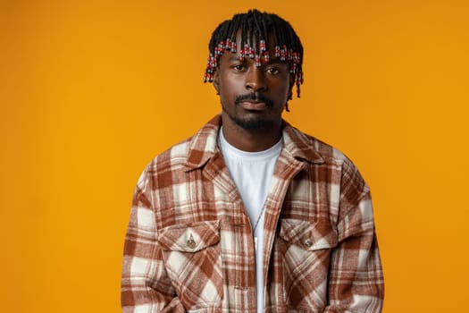 Young african man wearing casual clothes standing on yellow background, close up