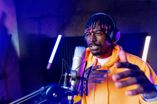 Young African performer recording his new track in recording studio, close up portrait