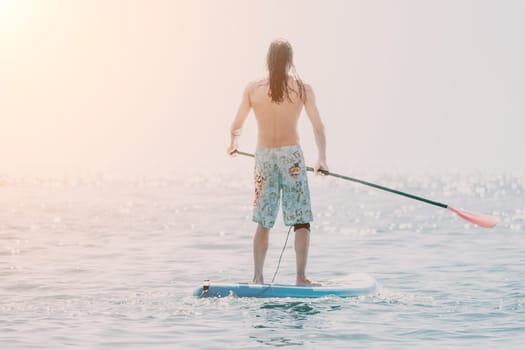 Man Sea Sup. Strong athletic man learns to paddle sup standing on board in open sea ocean on sunny day. Summer holiday vacation and travel concept. Aerial view. Slow motion.