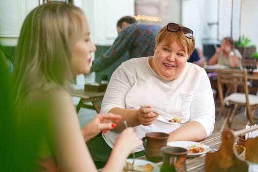 Portrait of two women, a mother and her daughter sitting in a outdoor cafe