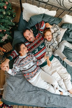 Happy family near fir-tree in bedroom, Christmas celebration at home close up