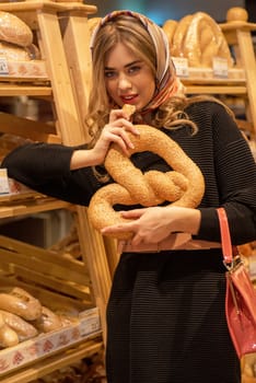 The young pretty woman in the bread depatment at the supermarket