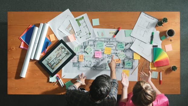 Top view of engineer working together to design building construction while standing at meeting table with blueprint and notes. Top view of interior designer choosing color from palettes. Symposium.