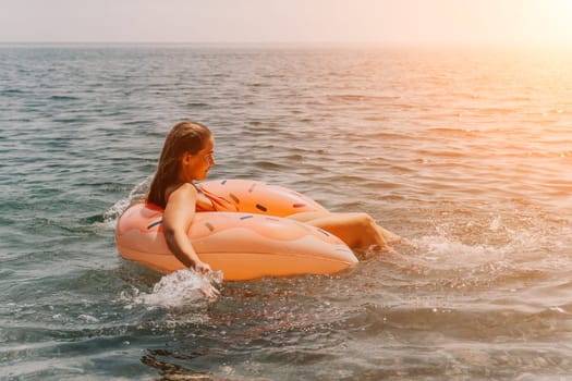 Summer Vacation Woman in hat floats on an inflatable donut mattress, a water toy swim ring. Unrecognizable young woman relaxing and enjoying family summer travel holidays vacation on the sea