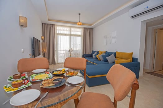 Living room lounge area in luxury apartment show home showing interior design decor furnishing with balcony terrace and dining table