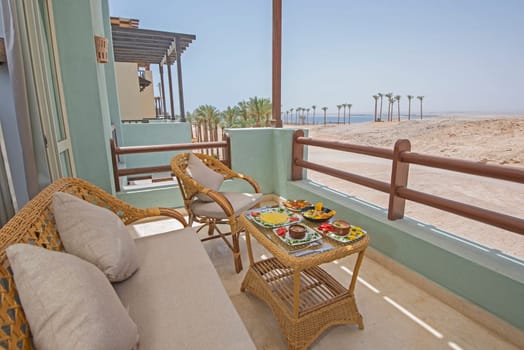 Terrace furniture of a luxury apartment in tropical resort with furniture and sea view from balcony with al fresco dining