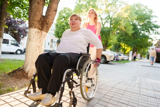 Young female caregiver pushing wheelchair with mature female person with disability across city street