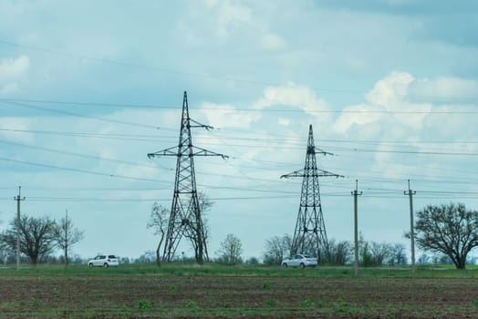 High voltage towers with sky background. Power line support with wires for electricity transmission. High voltage grid tower with wire cable at distribution station. Energy industry, energy saving.