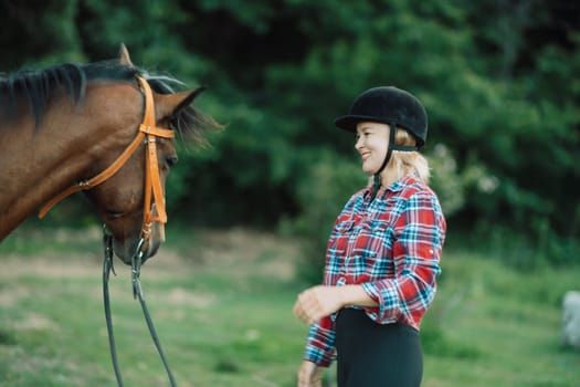 Happy blonde with horse in forest. Woman and a horse walking through the field during the day. Dressed in a plaid shirt and black leggings