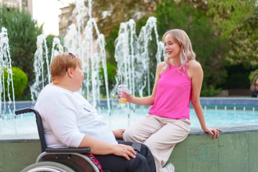 Young daughter taking care of her mother with disability sitting in wheelchair, portrait