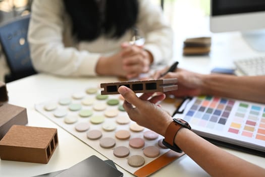 Interior designers working with furniture material samples at co working space in office.