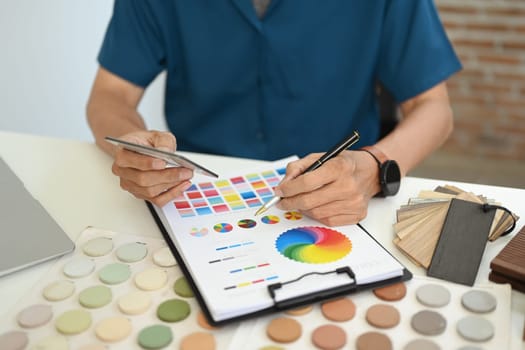 Cropped shot Interior designer comparing samples of different materials at table.