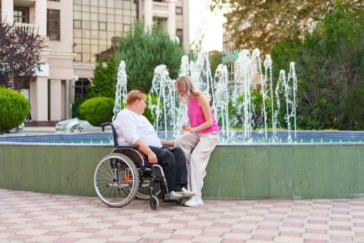 Young daughter taking care of her mother with disability sitting in wheelchair, portrait