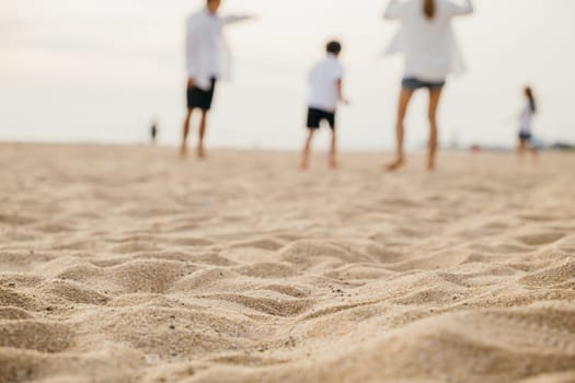 Cheerful family on the beach with parents and children playing walking and laughing. Summer holiday happiness carefree moments and family fun in the sun. Family on beach vacation