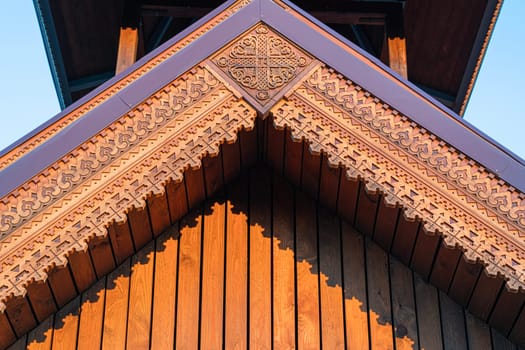 the facade of the building's roof is sheathed in carved wood. photo