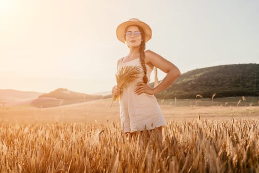 Woman farmer walks through a wheat field at sunset, touching green ears of wheat with his hands. Hand farmer is touching ears of wheat on field in sun, inspecting her harvest. Agricultural business.