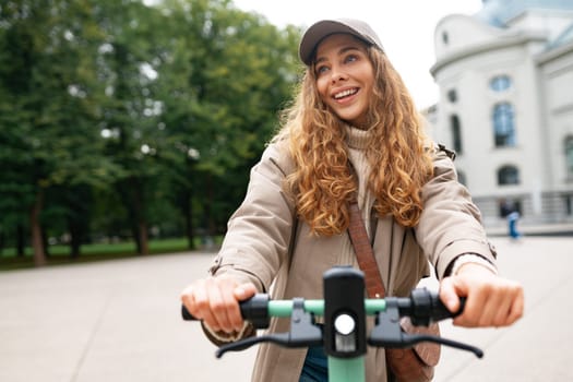 Young woman standing on electric scooter in the city, close up