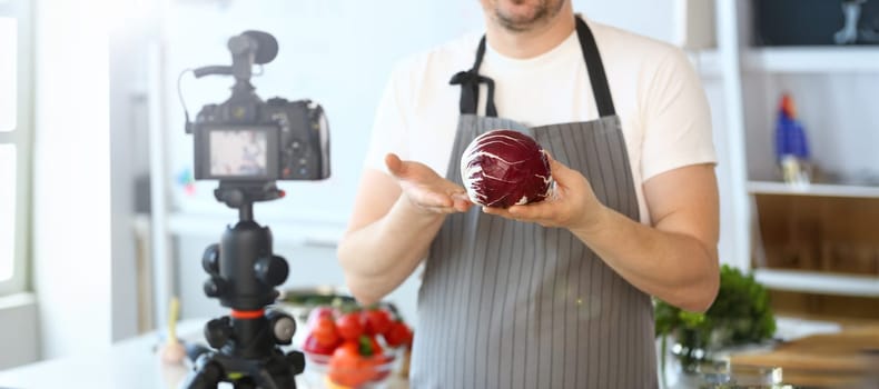 Chef Blogger Recording Cabbage Culinary Recipe. Man in Apron Holding Ripe Purple Cole in Hands. Healthy Nutrition Blog. Male Showing Organic Salad Ingredient. Fresh Vegetable Horizontal Shot