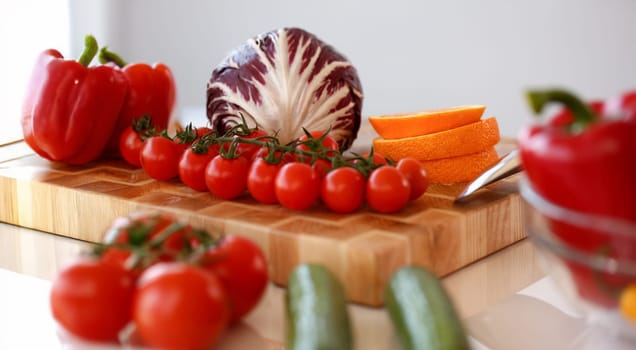 Assorted Raw Healthy Vegetable Food Photography. Red Tomatoes, Cabbage and Orange Fruit on Wooden Cutting Board. Vegan and Diet Ingredients in Kitchen. Healthy Lifestyle Culinary and Fresh Vitamins