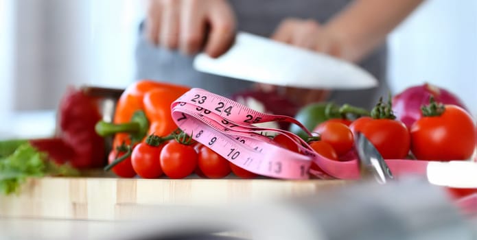 Organic Small Cherry Tomatoes Size Measurement. Fresh and Ripe Vegetables. Measuring of Culinary Ingredient with Pink Centimeter. Cooking with Sharp Knife Partial View Horizontal Photography