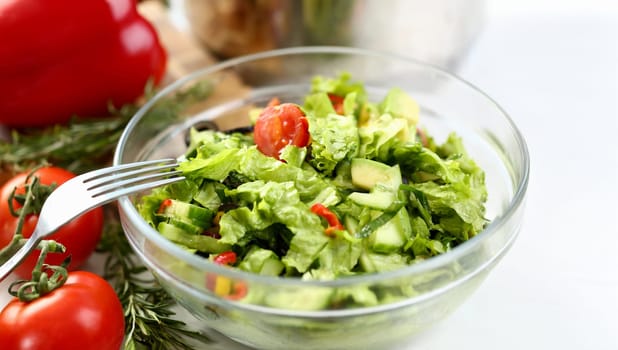 Healthy Organic Vegetable Salad Fork Photography. Fresh Dish with Chopped Green Lettuce, Cucumber and Red Cherry Tomato in Glass Bowl. Rosemary Herb on Kitchen Worktop. Home Culinary Horizontal Photo