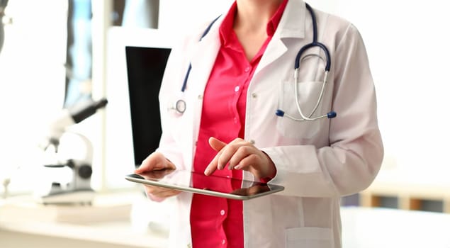 Woman Doctor Using Black Screen Computer Tablet. Medicine Physician Standing with Stethoscope in White Lab Coat. Female Hand Working with Hospital Digital Technology. Medical Information Search