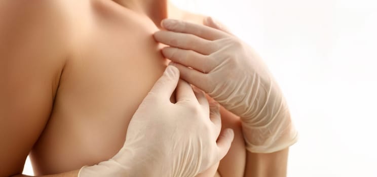 Naked Woman Examining Breasts Healthcare Portrait. Topless Female Checking Breast on White Background. Medical Bust Diagnostic with Hands in Gloves. Beautiful Body and Skin Partial View Shot