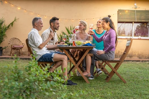 Friends eating happy in the backyard at home. High quality photo