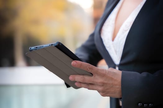 Portrait of a smiling middle-aged business woman with digital tablet in smiling hands looking at camera