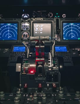 Cockpit view of an airplane during a night-time flight with illuminated instrument panels