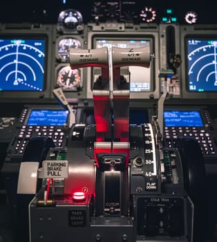 Cockpit view of an airplane during a night-time flight with illuminated instrument panels