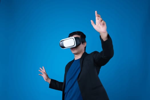 Profile businessman wearing VR headset looking to connect metaverse touching zoom in or out interesting business data isolated blue background futuristic technology in virtual reality. Contrivance.