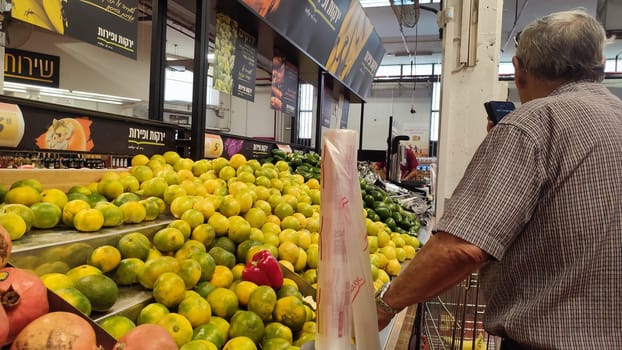 October 23, 2024 Beer Sheva Negev Israel, Shufersal supermarket, tangerine fruit, man buying. High quality photo