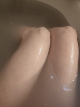 woman's feet in soapy bath water, cleanliness hygiene human health. High quality photo